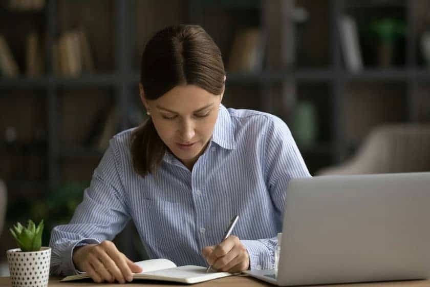 woman writing in journal min